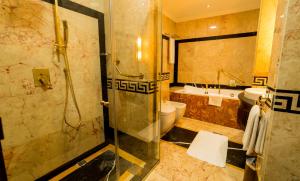 a bathroom with a tub, sink, and shower at Grand Excelsior Hotel Al Barsha in Dubai
