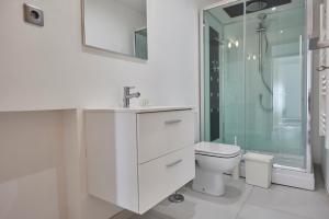 ein weißes Bad mit einem WC und einer Dusche in der Unterkunft APPARTEMENT T3 1er étage au calme, 6 couchages in Le Pin
