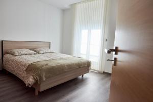 a bedroom with a bed and a large window at APPARTEMENT T3 1er étage au calme, 6 couchages in Le Pin