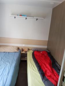 a small room with two beds and a red blanket at Mobil-home 75 au Camping Le Rioumajou in Bourisp