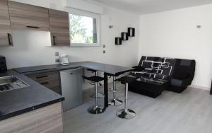 eine Küche mit einem Tisch, Stühlen und einem Sofa in der Unterkunft Au petit canal de COLMAR 2 in Kunheim