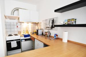 - une cuisine avec des appareils blancs et un comptoir en bois dans l'établissement Praktisches Apartment mit Flatscreen TV, à Leverkusen