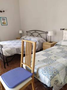 um quarto com duas camas e uma cadeira. em B&B A Casa Di GioSi em Catânia