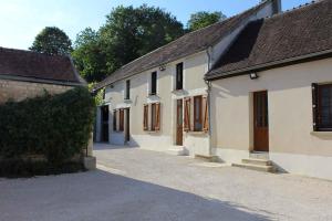 a row of white buildings with trees in the background at Le Bacchus in Chablis