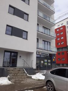 een auto geparkeerd voor een gebouw bij Apartament Coresi in Braşov