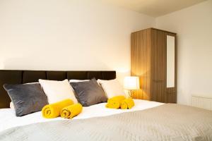 Un dormitorio con una cama con almohadas amarillas. en Carvetii - Kings House - 20mins to Edinburgh, en Inverkeithing