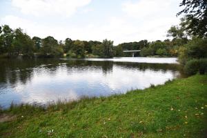 a large lake in a park with trees and grass at Praktisches Apartment mit Flatscreen TV in Leverkusen