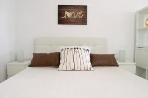 ein Bett mit zwei Kissen darauf in der Unterkunft Edificio Seguro de Sol, Puerto La Cruz, Islas Canarias Tenerife in Puerto de la Cruz + 18 Fotos