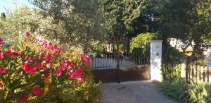 a gate in a fence with pink flowers in front at Gite Pont de Crillon in Crillon-le-Brave +56 photos