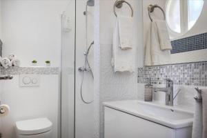 een witte badkamer met een wastafel en een douche bij Kaleta garden apartment in Split