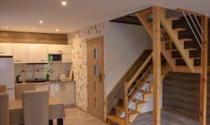 a kitchen and a living room with a staircase in a tiny house at Domek Nad Brzegiem in Witanowice