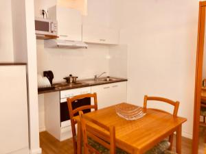 a small kitchen with a wooden table and chairs at Apartment Abendstern in Berlin