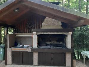 an outdoor kitchen with a grill and a sink at Kuća za odmor Villa.ris in Lokve
