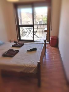 ポルトにあるQuarto com 4 camas (Beliches+ 1 Sofá-cama)のバルコニー付きの客室のベッド1台分です。