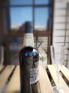 ポルトにあるQuarto com 4 camas (Beliches+ 1 Sofá-cama)のグラスワインの横に置かれたワイン1本