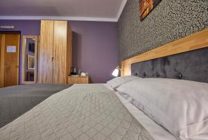 a bedroom with a large bed and a wall at Fifth Ocean SPA Hotel in Truskavets