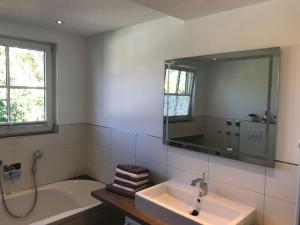a bathroom with a tub and a sink and a mirror at Wendlers Ferienwohnungen #7 in Schwaig bei Nürnberg +39 photos