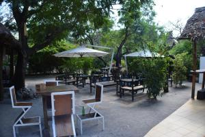 an outdoor patio with tables and chairs and umbrellas at Triniti Oysterbay in Dar es Salaam