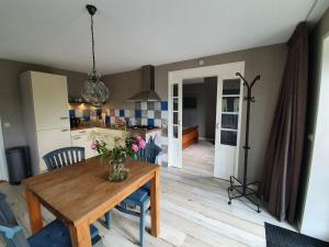 a kitchen and dining room with a wooden table at Gastenverblijf De Natureluur in Noorden