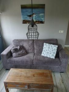 a living room with a couch and a coffee table at Gastenverblijf De Natureluur in Noorden