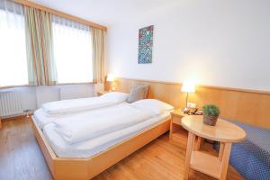 um quarto com uma cama e uma mesa com um candeeiro em Pension Café Maier em Golling an der Salzach