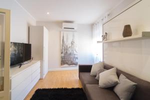 a living room with a couch and a flat screen tv at Palazzo RICCA GUARDUCCI 2 in Montefiascone