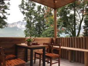 a table and chairs on a porch with a view at Enshi Grand Canyon Chunlun Farmstay in Enshi