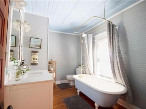 a bathroom with a tub and a sink and a toilet at Belton Bed and Breakfast in Belton