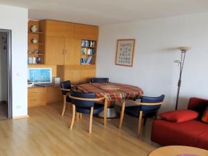 - un salon avec une table, des chaises et un canapé dans l'établissement Ostsee-Residenz 17, à Damp
