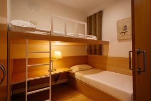 バルセロナにあるウェロ アパートメンツの小さなお部屋で、二段ベッド2組、ランプが備わります。