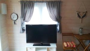une télévision assise sur une table devant une fenêtre dans l'établissement Domek w Karkonoszach, à Zachełmie
