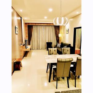 uma sala de jantar e sala de estar com mesa e cadeiras em Imperial Grand Suite Apartment Kuching em Kuching