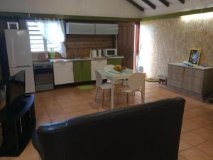 eine Küche mit Tisch und Stühlen in einem Zimmer in der Unterkunft Grand studio Cacao 1 in Baie-Mahault