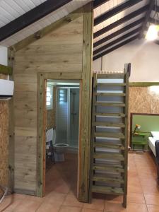 ein Raum mit einer Holzwand und einer Leiter in der Unterkunft Grand studio Cacao 1 in Baie-Mahault
