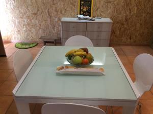 einen weißen Tisch mit einer Schale Obst drauf. in der Unterkunft Grand studio Cacao 1 in Baie-Mahault + 15 Fotos