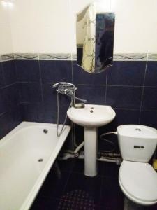a bathroom with a sink and a toilet and a bath tub at Квартира на Ленина in Okhtyrka