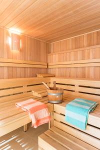 a wooden sauna with two towels and a bucket at Pierre & Vacances Empuriabrava Marina in Empuriabrava