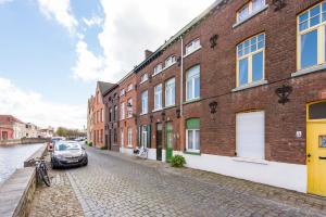 une rue avec des bâtiments et une voiture garée à côté d'un canal dans l'établissement Charming Place along the Canals in Bruges, à Bruges