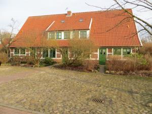 ein Haus mit einem orangenen Dach und einer Auffahrt in der Unterkunft Gästehaus Howe in Stade