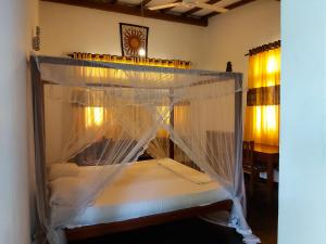 1 cama con dosel en una habitación en Sunstyle Mirissa Guest House en Mirissa