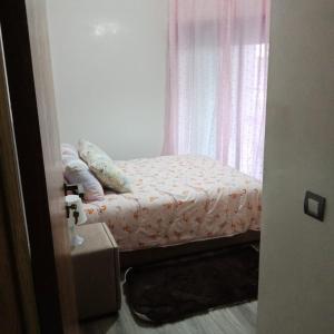 een klein bed in een kamer met een raam bij Studio Des Nations Miramar Mohammedia in Mohammedia