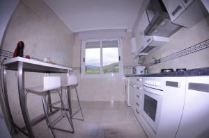 una cocina con electrodomésticos blancos y una ventana en APARTAMENTOS URDAIBAI 4, en Busturia