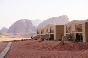 een gebouw in de woestijn met bergen op de achtergrond bij Zeina Desert Lodge in Wadi Rum