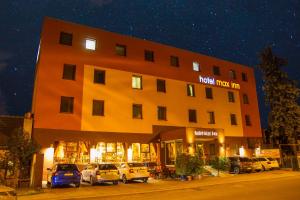 a hotel with cars parked outside of it at night at Hotel Max Inn in Bratislava