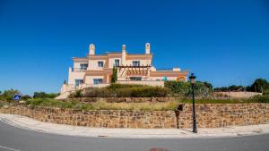 uma grande casa sentada em cima de uma parede de pedra em Villas @ Quinta do Vale Golfe em Castro Marim