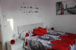 ein Schlafzimmer mit einem Bett mit roten Kissen und einer Wand in der Unterkunft Pisa Apartment Tower in Pisa