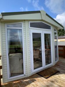 une véranda avec des portes en verre sur une terrasse dans l'établissement Invernevis, à Boat of Garten