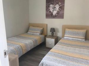 ベナルマデナにあるBenalmadena Costa Las Nacionesのベッドルーム1室(ベッド2台、ナイトスタンドのランプ付)