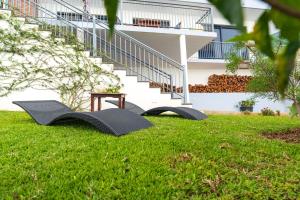 two chairs on the grass in front of a building at Apartamento Goncalves in Arco da Calheta