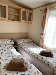 two twin beds in a room with a window at Invernevis in Boat of Garten